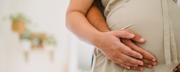 Hands touching pregnant woman