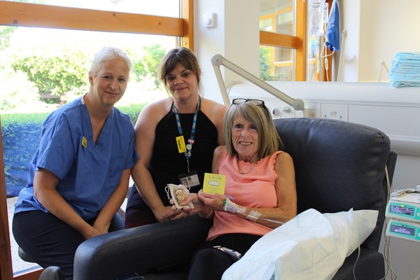 Macmillan Renton Unit patient receiving teddy bear gift pack from hospital staff