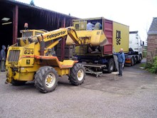 a yellow forklift truck loads a container, ready to be sent to Muheza